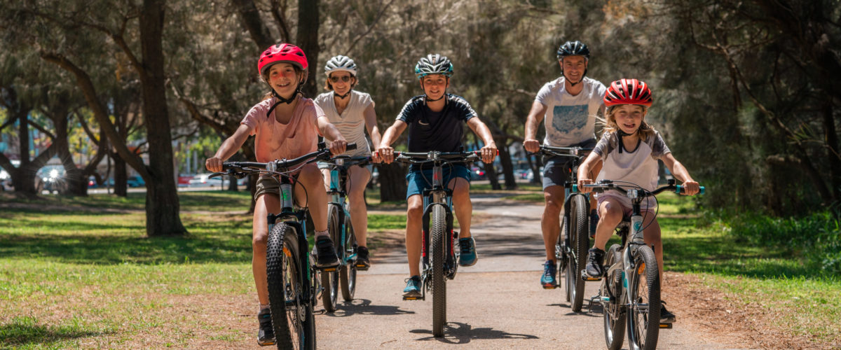 Family cycling through forest on cycling tour