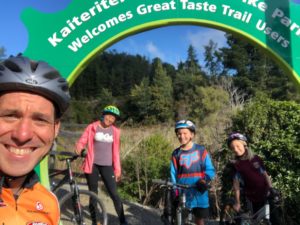 Family under Kaiteriteri mountain bike park sign